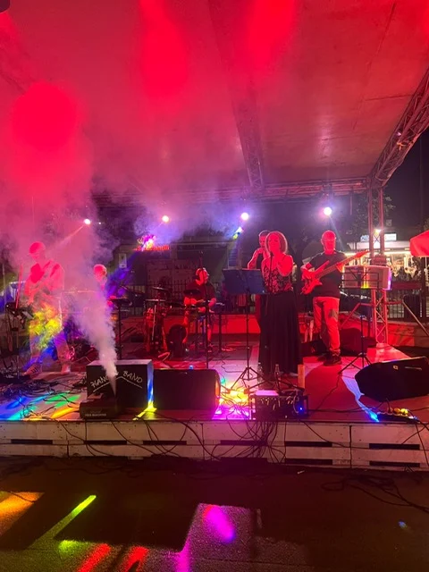 Palco con impianto audio e luci rosse durante un concerto